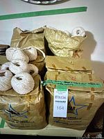 Six brown paper bags labeled Star Brand Candlewick by Cosmos Imperial Mills Limited, some bags slightly crumpled, with balls of natural candlewick string on top and beside the bags.