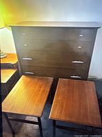 Front view of mid-century modern solid wood dresser with two teak side tables in front