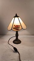 Front view of lit Tiffany-style table lamp with fox image on glass panel