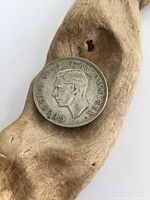 Obverse side of the 1944 silver two shillings coin showing the profile of King George VI with inscriptions around the edge