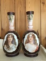 Front view of the two tall antique opaline glass vases with hand painted female portraits and brown and cream color tones.
