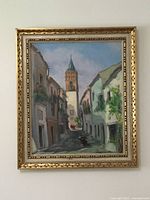 Full view of the framed oil painting showing the street scene and tower under blue sky.