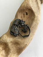 Front and angled view of the vintage sterling silver cat brooch on wood background