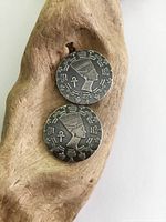 Two Egyptian silver coins showing profile of a queen or pharaoh with hieroglyphics