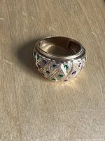 Front angle of dome ring showing crisscross pattern and colored enamel dots on 14K gold band