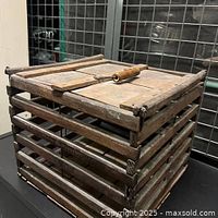 Side angled view of the wooden egg carrier showing horizontal wooden slats and wooden top lid with handle.