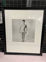 Front view of framed black and white male nude photograph with white mat and black frame