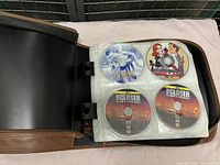 Photo showing four DVDs in a black binder. Titles 'The Closer' on two discs, a Star Wars themed disc, and a Family Guy disc.