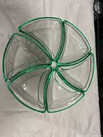 Top-down view showing all six triangular green glass dishes arranged in a circular nesting pattern with edges touching, highlighting shape and color.