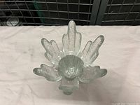 Top view showing circular opening and starburst/flame petal pattern in clear textured glass