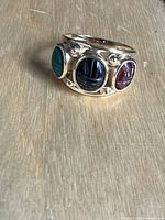 Front three-quarter view showing all three scarab stones in bezel settings