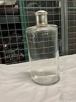 Front view of the clear crystal bottle with sterling silver cap showing dent on top