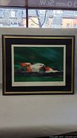 Full view of the framed artwork with racing car image and signature visible.