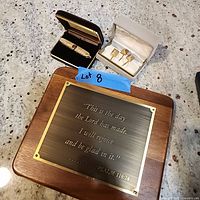 Photo showing wooden plaque with brass-colored metal plate featuring Psalm 118:24.