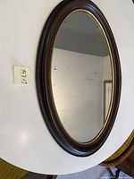 Front view of the antique oval mirror showing wood frame and mirror surface