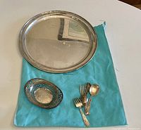 Tray, pierced dish and flatware displayed on Tiffany & Co. cloth