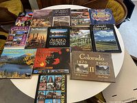 Collection of large tourism books with colorful glossy covers featuring travel sites in America, Colorado, and other locations.