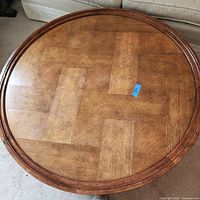 Top view of the round wood coffee table showing parquet-style wood pattern on the surface and wooden rim.