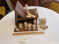 View of wooden stable with most nativity figurines arranged around it with ruler for scale