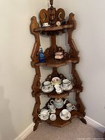 Full view of folding wood display stand with china items arranged on shelves