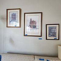 Overview of three framed prints hanging on a wall above a sofa