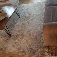 View of textured multi-color living room rug with subtle pattern beneath coffee table and sofa