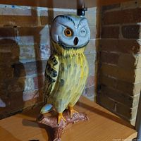 Full side view of the hand-painted Italian pottery owl figurine on branch base.