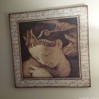 Front view of framed art print showing a woman's profile with decorative headwear and scripted border.