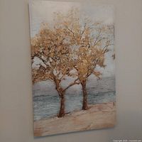 Canvas art depicting two leafy trees with water background, in warm earth tones and blue hues