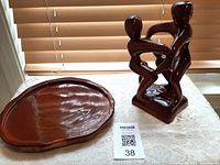 Small polished mahogany tray with an oval shape showing natural wood grain on surface