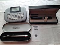 Sheaffer fountain pen in black box with ink cartridges, Cadence pen in metal case, Brother M95 label maker keyboard visible