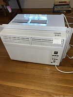 Front view of GE window air conditioner showing control panel and air vents with MaxSold tag.