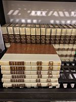 Photo of 15 hardcover Funk & Wagnalls New Encyclopedia Yearbooks from 1985 to 1999 showing uniform bindings with black and gold spine titles.
