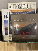 Top view photo showing three publications including Canada Year Book 1997 and The Automobile magazine, packed in a box.