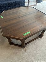 Polygonal traditional wooden coffee table top showing polished wood surface with some minor surface wear.