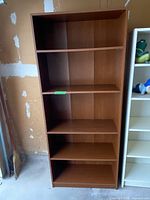 Front view of wood veneer bookshelf with five shelves
