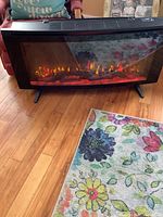 Front view of the Napoleon electric fireplace showing flame effects and wood logs inside.