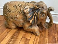 Side view of the elephant sculpture showcasing detailed carvings and curled trunk.