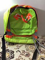 Front view showing neon yellow perforated fabric, orange accents, and external grey loops.