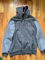 Front view of grey Hurley zip-up hoodie showing full length and brand logo on chest