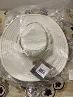 Off-white wide-brimmed fishing hat in original plastic packaging, showing the full hat and tags.