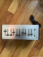 Front view of vintage Realistic stereo equalizer showing multiple frequency sliders and power switch.