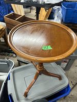 Top view of the round wooden table showing its 15 inch diameter and smooth surface with a raised edge.