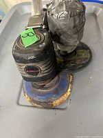 Photo of black Airco air sander showing worn sanding pad and top branding