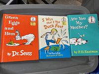 Photo showing three vintage Dr. Seuss children's books on a gray surface: 'Green Eggs and Ham,' 'I Wish That I Had Duck Feet,' and 'Are You My Mother?'. All books are in good, like-new condition.