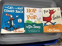Three vintage Dr. Seuss hardcover books lying side by side on a surface. Titles are The Cat in the Hat Comes Back, Hop on Pop, and Fox in Socks.