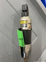 Front view of the air punch/flange tool, showing handle, metal body, and punch head.