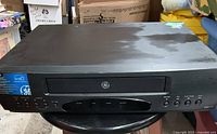 Front view of GE VHS player showing cassette tray and control buttons.