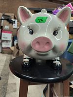 Front view of ceramic piggy bank with detailed face, pink snout, long eyelashes and rosy cheeks.