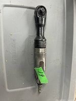 Full view of the used pneumatic air ratchet showing the black ratchet head and the main silver/gray body with a trigger lever.